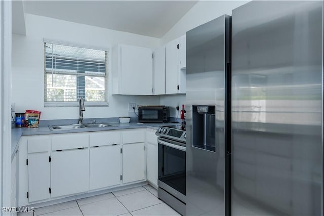 kitchen featuring a sink, stainless steel appliances, light tile patterned floors, and white cabinetry