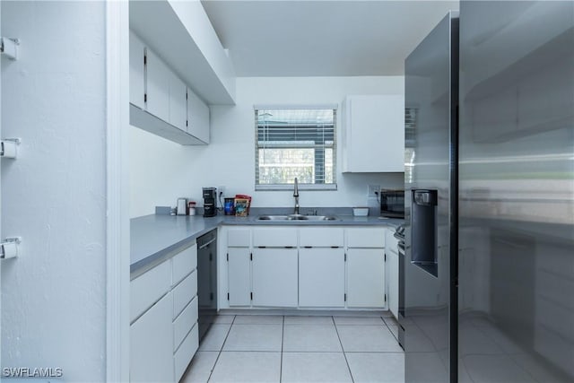 kitchen featuring black appliances, a sink, light tile patterned flooring, white cabinets, and light countertops