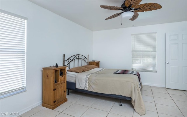 bedroom featuring light tile patterned flooring, ceiling fan, baseboards, and multiple windows