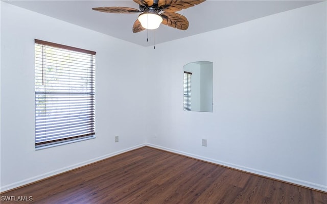 spare room featuring wood finished floors, a ceiling fan, arched walkways, and baseboards