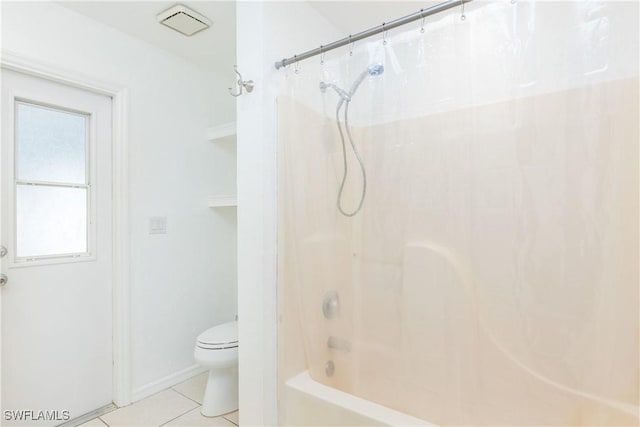 bathroom featuring tile patterned floors, toilet, and bathing tub / shower combination