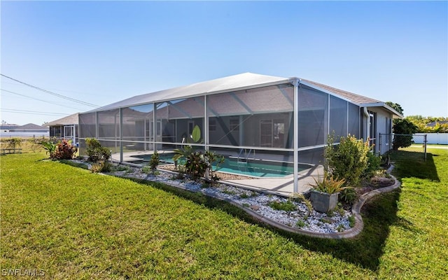 rear view of property featuring glass enclosure, a lawn, a fenced in pool, and fence