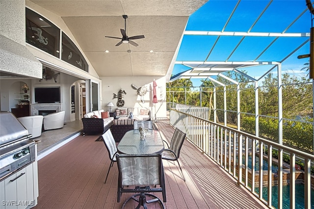 wooden deck featuring glass enclosure, an outdoor living space, and a ceiling fan