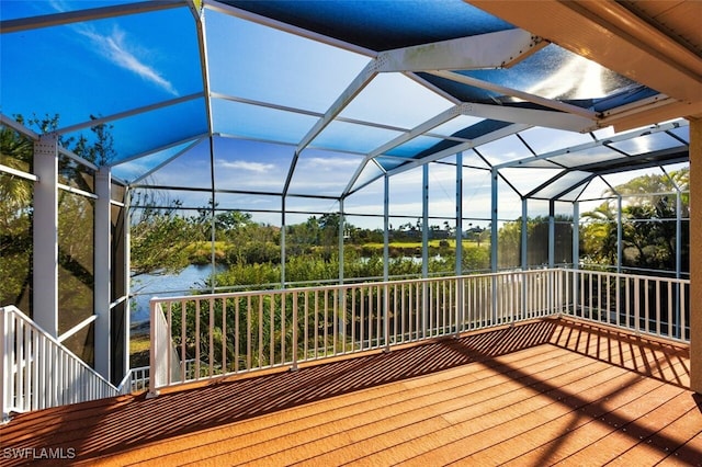 deck with glass enclosure and a water view