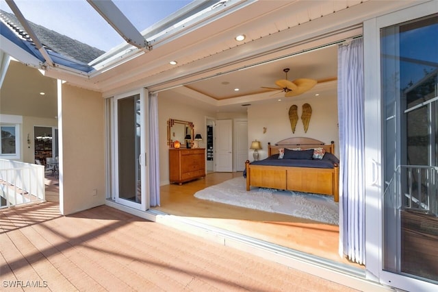 bedroom with a tray ceiling, wood finished floors, and recessed lighting