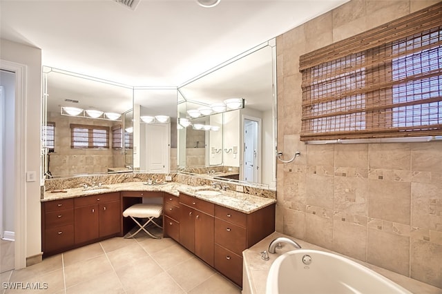 bathroom with a garden tub, tile patterned flooring, and vanity