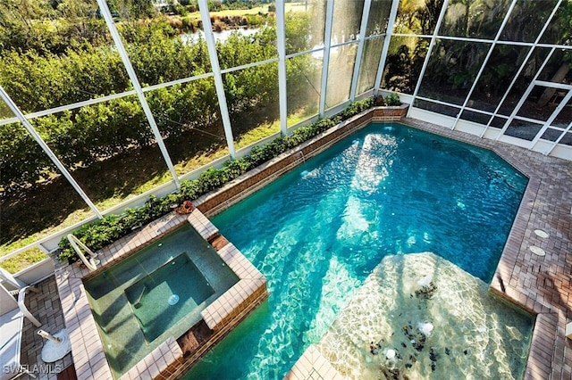 view of pool featuring a lanai and a pool with connected hot tub