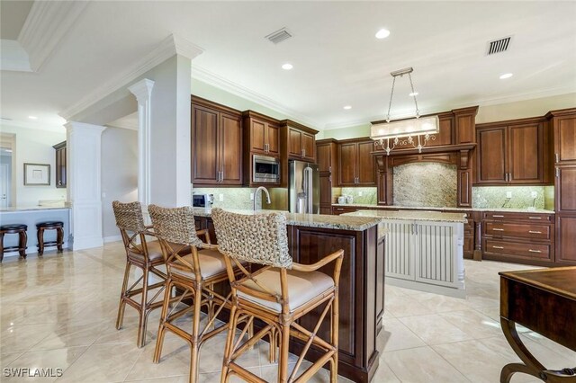 kitchen with a kitchen bar, visible vents, stainless steel appliances, and a sink