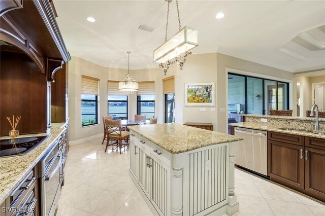 kitchen with a kitchen island, a sink, hanging light fixtures, ornamental molding, and appliances with stainless steel finishes