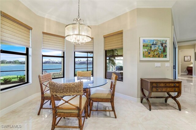 dining space with a wealth of natural light, a water view, crown molding, and an inviting chandelier