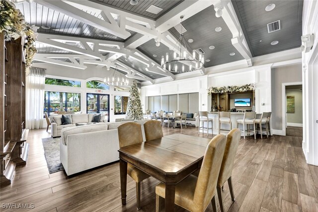 dining room featuring high vaulted ceiling, visible vents, a chandelier, and wood finished floors