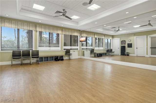 interior space with a tray ceiling, visible vents, and ceiling fan