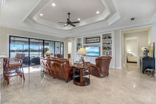 living area with crown molding, a tray ceiling, a ceiling fan, and built in features