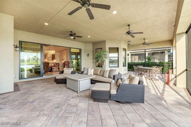 view of patio with a ceiling fan, outdoor dining area, and an outdoor hangout area