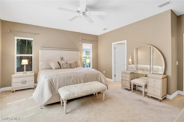 bedroom featuring visible vents, light colored carpet, a ceiling fan, and baseboards