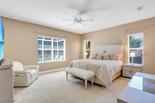 bedroom featuring visible vents, light carpet, multiple windows, and baseboards