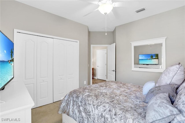 bedroom featuring ceiling fan, visible vents, a closet, and light carpet