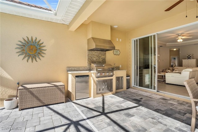 view of patio with ceiling fan, a grill, and an outdoor kitchen