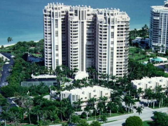 view of building exterior featuring a city view, central air condition unit, and a water view