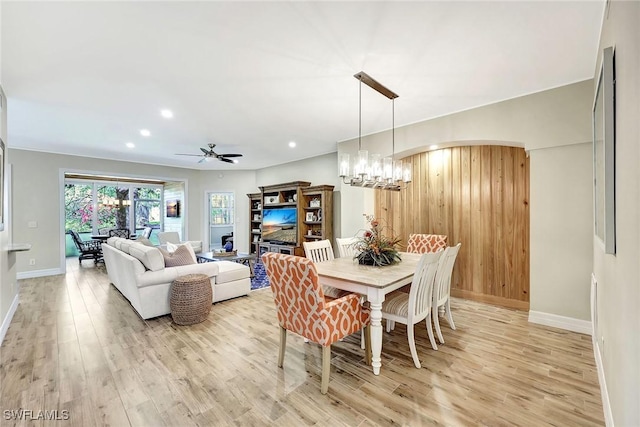 dining room with light wood-style floors, baseboards, arched walkways, and recessed lighting