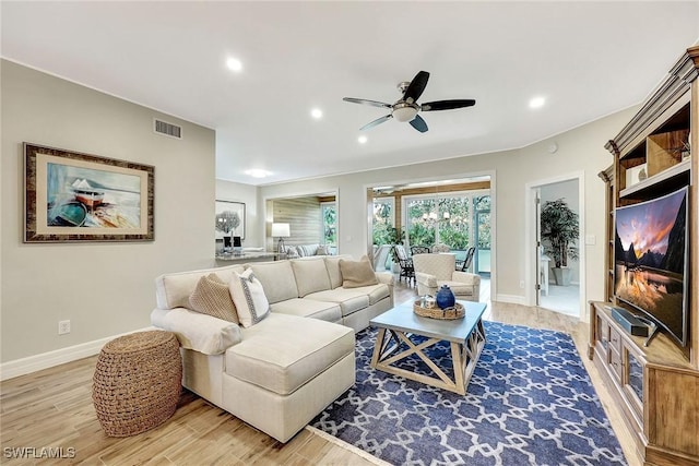 living room featuring light wood-type flooring, visible vents, baseboards, and recessed lighting