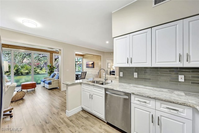 kitchen featuring a sink, tasteful backsplash, white cabinetry, and stainless steel dishwasher