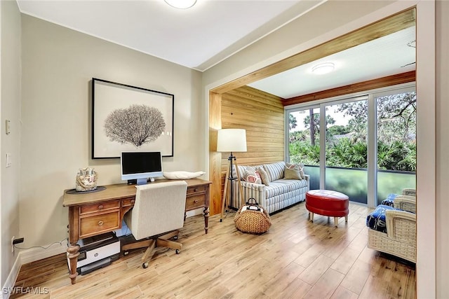 office featuring wooden walls, baseboards, and wood finished floors