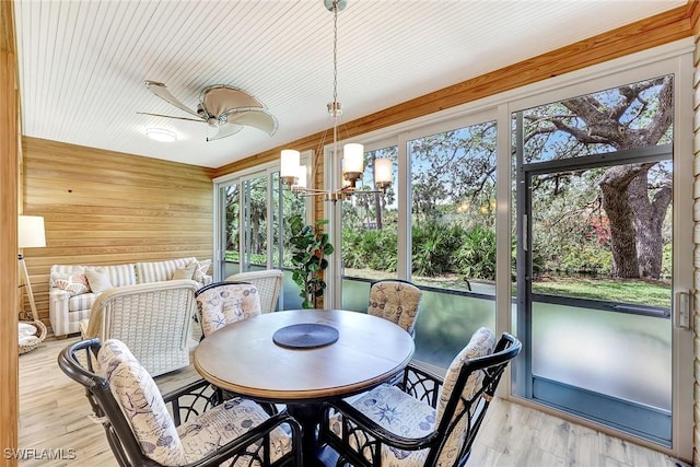 sunroom / solarium with ceiling fan with notable chandelier