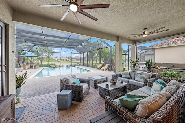 pool with ceiling fan, a patio, outdoor lounge area, and glass enclosure