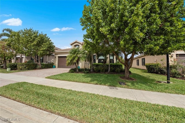 view of property hidden behind natural elements featuring decorative driveway, a tile roof, stucco siding, a garage, and a front lawn