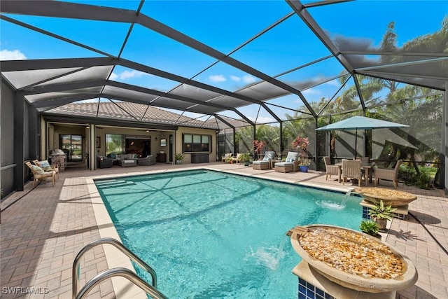 outdoor pool with glass enclosure, a patio area, and outdoor lounge area