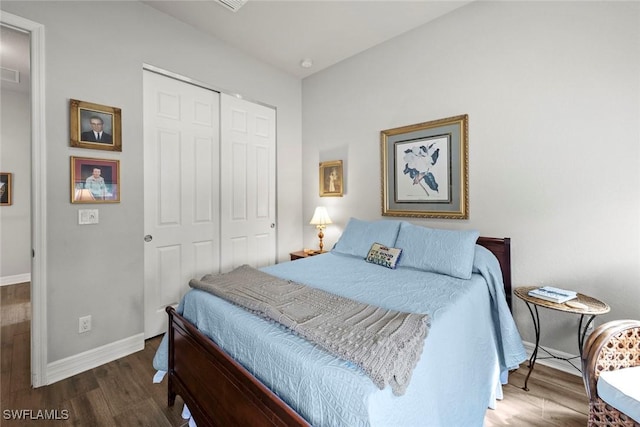 bedroom with a closet, baseboards, and wood finished floors