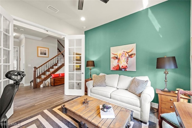 living area with wood finished floors, visible vents, baseboards, stairs, and french doors