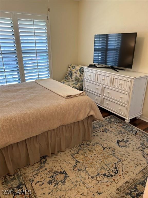 bedroom with dark wood-style flooring