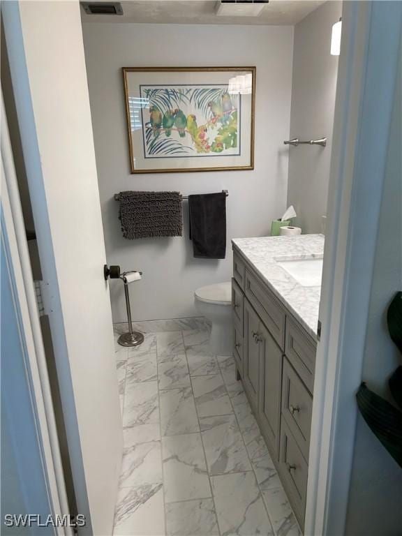 bathroom featuring visible vents, marble finish floor, toilet, and vanity