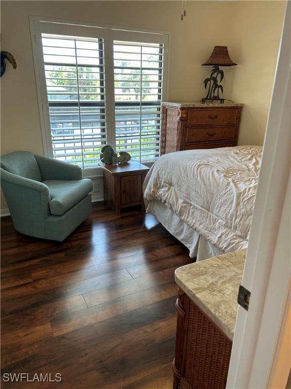 bedroom with dark wood-style flooring