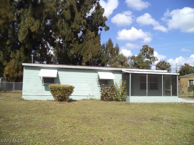 back of house with a yard, fence, and a sunroom