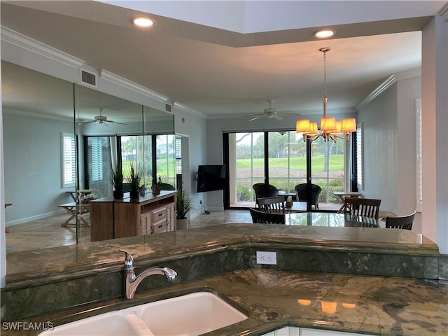 kitchen with baseboards, visible vents, ornamental molding, open floor plan, and a sink