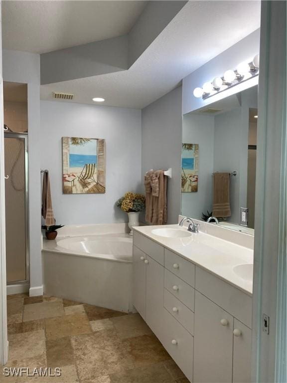 full bath with a garden tub, double vanity, visible vents, a stall shower, and a sink