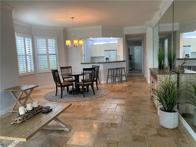 dining area with baseboards, crown molding, stone tile floors, and an inviting chandelier