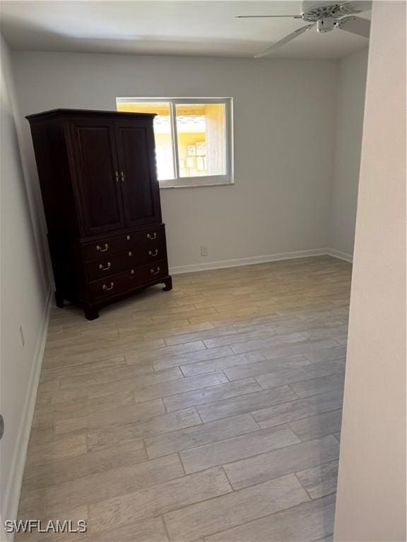 unfurnished bedroom featuring light wood-style floors, baseboards, and a ceiling fan