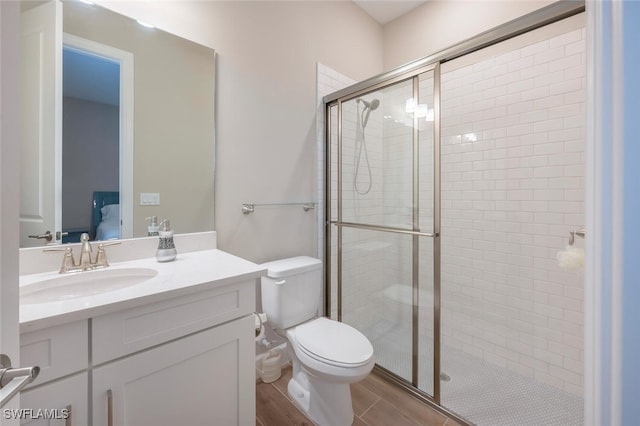 bathroom featuring ensuite bathroom, a stall shower, vanity, and toilet