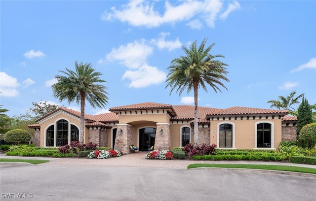 mediterranean / spanish-style home with a tiled roof and stucco siding