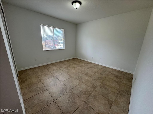 unfurnished room with baseboards