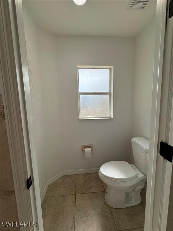 bathroom with toilet, baseboards, visible vents, and tile patterned floors