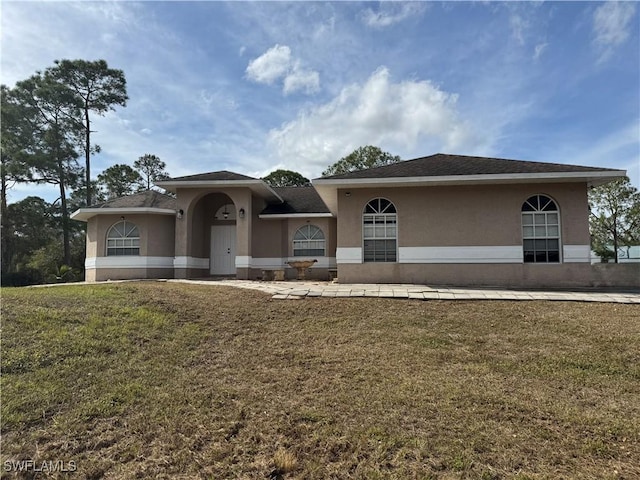 view of front facade with a front yard and stucco siding