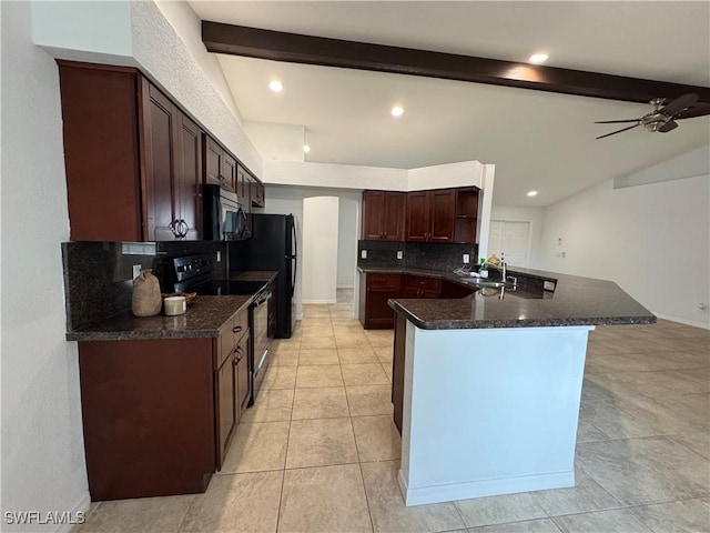 kitchen featuring electric range, decorative backsplash, dark countertops, stainless steel microwave, and a sink