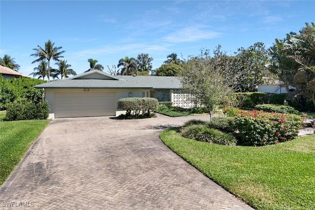 single story home with a garage, stucco siding, decorative driveway, and a front yard