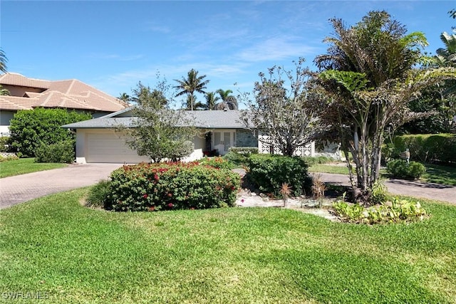 view of front of house with decorative driveway, a garage, and a front yard