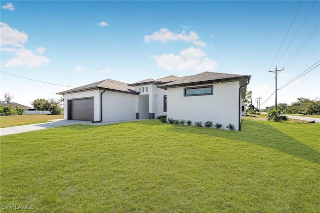 prairie-style house featuring a garage, concrete driveway, a front yard, and stucco siding